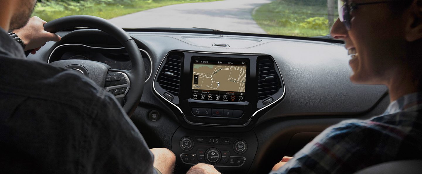An interior view of the 2020 Jeep Cherokee with the Uconnect touchscreen displaying a route map.