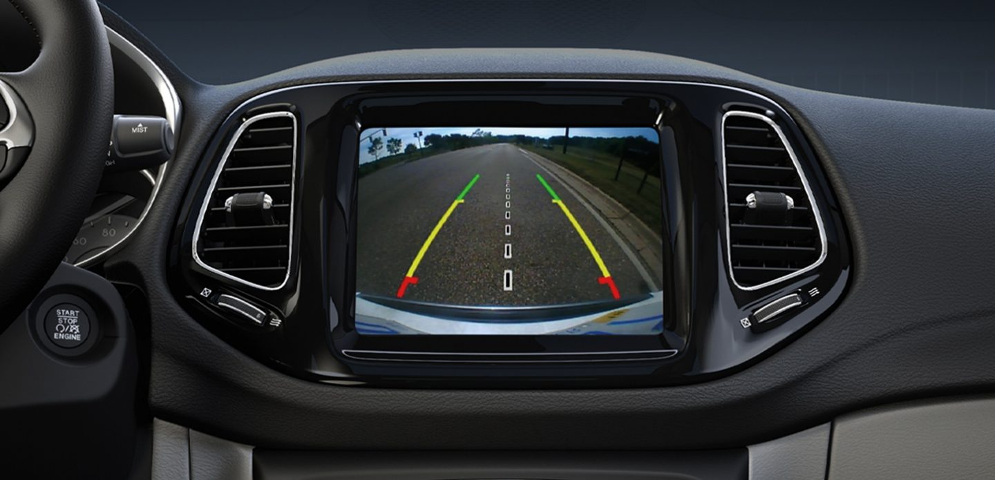 The Uconnect touchscreen in thee 2020 Jeep Compass displaying an image from the rear camera, while moving in reverse.