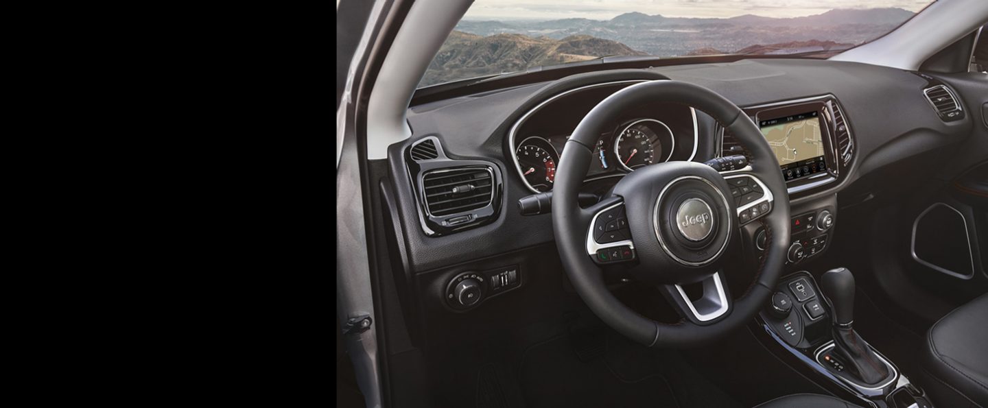 The steering wheel, instrument panel, touchscreen and center console on the 2020 Jeep Compass.