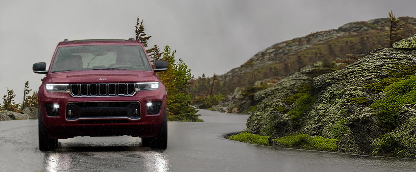 The 2021 Jeep Grand Cherokee L Overland being driven on a rain-slicked road.