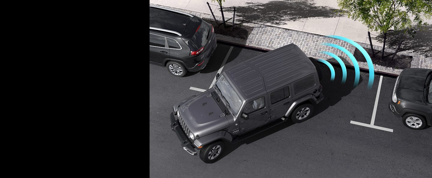 The 2022 Jeep Wrangler Sahara as it backs into a curbside parking spot, with illustrated sensor bars emanating from its rear.
